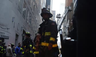 epa10579305 New York City Fire Department firefighters work on ladder trucks at the scene of a  parking structure collapse in the Financial District of New York City, New York, USA, 18 April 2023. Fire Department officials have reported three injuries but advised they expect that to increase.  EPA/JUSTIN LANE