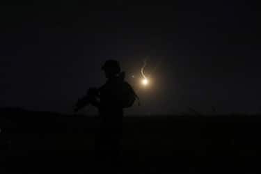 The silhouette of an Israeli soldier is outlined in the sky by a flare fired to search for a rocket that landed near Kibbutz Meitsar in the Israeli annexed Golan Heights, April 9, 2023. - Israel launched artillery strikes on Syria early morning on April 8 after several rockets were fired from there and landed in the Israeli-occupied Golan Heights. Israel's retaliatory strike to rocket attacks from Syria -- which no one has claimed -- is the latest episode in escalating violence in the region. (Photo by JALAA MAREY / AFP) (Photo by JALAA MAREY/AFP via Getty Images)