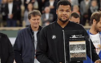 epa09972396 Jo-Wilfried Tsonga of France reacts with his trophy after losing against Casper Ruud of Norway in their menâ  s first round match and ending his career during the French Open tennis tournament at Roland â  Garros in Paris, France, 24 May 2022.  EPA/CHRISTOPHE PETIT TESSON