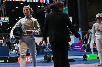 Ukraine's Olga Kharlan (L) leaves the fencing strip after she refused to shake hands with Russia's Anna Smirnova (R), registered as an Individual Neutral Athlete (AIN), after Kharlan defeated Smirnova during the Sabre Women's Senior Individual qualifiers, as part of the FIE Fencing World Championships at the Fair Allianz MI.CO (Milano Convegni) in Milan, on July 27, 2023. (Photo by Andreas SOLARO / AFP)