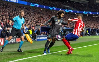 epa08226748 Atletico's defender Renan Lodi (R) vies for the ball against Liverpool's winger Mohamed Salah (C) during the UEFA Champions League round of 16 first leg match between Atletico de Madrid and Liverpool FC at Wanda Metropolitano in Madrid, Spain, 18 February 2020.  EPA/RODRIGO JIMENEZ