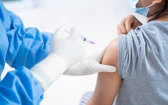 Doctor making a vaccination in the shoulder of patient teens girls person, Flu Vaccination Injection on Arm, coronavirus,covid-19 vaccine disease preparing for human clinical trials vaccination shot