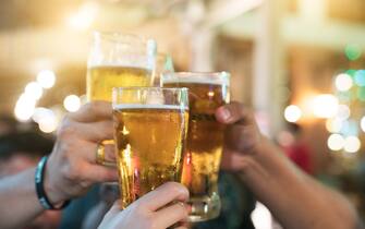 Group of happy friends drinking and toasting beer at brewery bar restaurant