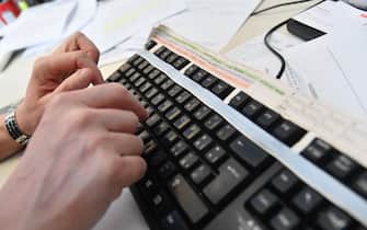 Un impiegato lavora al computer nel suo ufficio, 19 marzo 2018 a Genova.
ANSA/LUCA ZENNARO