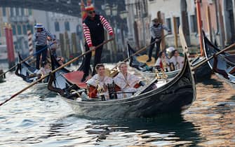 Due giovani Marie del Carnevale salutano la folla, a bordo di una gondola, durante il corteo sul Canal Grande verso piazza San Marco, Venezia, 03 febbraio 2024. 
ANSA/ANDREA MEROLA