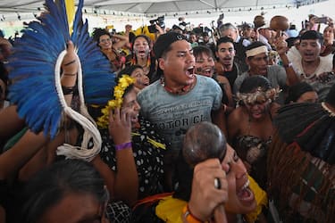 epa10875430 Indigenous people celebrate the favorable vote during a broadcast of the 'Temporal Framework' trial on a screen installed in front of the Supreme Federal Court (STF) in Brasilia, Brazil, 21 September 2023. The Supreme Court of Brazil on 21 September reached a majority of votes necessary to recognize the right of Indigenous people to lands they historically occupied, rejected by large rural businessmen and far-right political groups. With three votes still missing, six of the eleven magistrates have already spoken out against the so-called 'temporary framework' (Marco Temporal, or time limit) legal thesis, which proposes limiting these rights to the lands that Indigenous people occupied on 05 October 1988, when the current Brazilian Constitution was promulgated.  EPA/Andre Borges