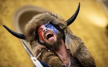 WASHINGTON, DC - JANUARY 06: Jacob Chansley, also known as the "QAnon Shaman," screams "Freedom" inside the U.S. Senate chamber after the U.S. Capitol was breached by a mob during a joint session of Congress on January 6, 2021 in Washington, DC. Congress held a joint session to ratify President-elect Joe Biden's 306-232 Electoral College win over President Donald Trump. Pro-Trump protesters illegally entered the U.S. Capitol building following rallies in the nation's capital. (Photo by Win McNamee/Getty Images)