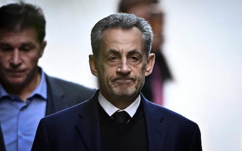 France's former president Nicolas Sarkozy leaves his residence to present himself to La Sante Prison for incarceration on a five-year prison sentence after being convicted of criminal conspiracy over a plan for late Libyan dictator Moamer Kadhafi to fund his 2007 electoral campaign, in Paris, on October 21, 2025. Nicolas Sarkozy, who has faced a flurry of legal woes since losing re-election in 2012, is to be jailed on October 21, 2025, over a scheme to acquire Libyan funding for his successful 2007 presidential run, becoming the first former head of a European Union country to serve time behind bars. The former French right-wing leader has appealed the verdict and denounced an "injustice". (Photo by JULIEN DE ROSA / AFP)
