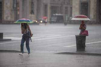 Turisti e cittadini si riparano dalla pioggia a Milano, 28 agosto 2023. ANSA/DAVIDE CANELLA