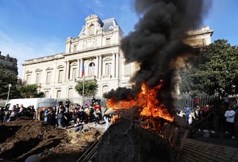 epa11105703 French farmers burn wooden pallets and hay during a farmers' protest in front of prefecture of Montpellier, France, 26 January 2024. French farmers continue their protests with road blockades and demonstrations in front of state buildings awaiting a response from the government to their request for  immediate  aid of several hundred million euros. On 23 January, the EU Agriculture and Fisheries Council highlighted the importance of providing the conditions necessary to enable EU farmers to ensure food security sustainably and profitably, as well as ensuring a fair income for farmers.  EPA/GUILLAUME HORCAJUELO