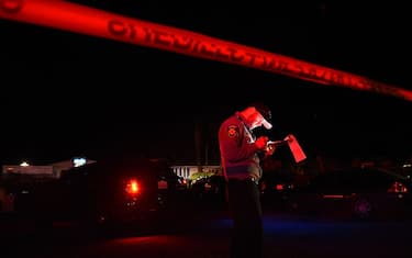 TOPSHOT - A San Mateo County sheriff deputy stands at the scene of a shooting on highway 92 in Half Moon Bay, California on January 23, 2023. - An Asian farm worker was in custody January 23, 2023 after seven of his colleagues were killed in front of children at sites in California, days after a mass shooter killed 11 people at a Lunar New Year celebration near Los Angeles. The latest bloodshed to hit Asian Americans in California occurred at two farms around Half Moon Bay, a coastal community near San Francisco. (Photo by Susana BATES / AFP) (Photo by SUSANA BATES/AFP via Getty Images)