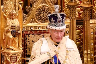 Britain's King Charles III, wearing the Imperial State Crown and the Robe of State, sits on The Sovereign's Throne in the House of Lords chamber, during the State Opening of Parliament, at the Houses of Parliament, in London, on November 7, 2023. (Photo by Leon Neal / POOL / AFP)