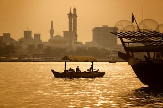 UAE, Dubai, Abra boat on Dubai Creek with the Grand Mosque behind (Photo by: Eye Ubiquitous/Universal Images Group via Getty Images)