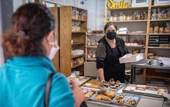 Una donna in panetteria con la mascherina