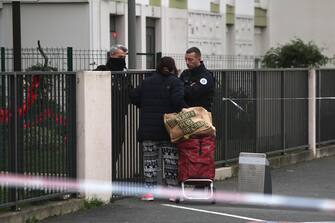 epa11044460 French police control a woman in front of a building where five bodies were found dead in Meaux, near Paris, France, 26 December 2023. Five bodies, of a mother and her four children were found dead by French police in an apartment on the evening of 25 December. Jean-Baptiste Bladier, the local prosecutor confirmed that a homicide investigation has been launched after the five bodies were found.  EPA/Christophe Petit Tesson