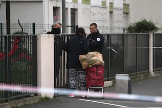 epa11044460 French police control a woman in front of a building where five bodies were found dead in Meaux, near Paris, France, 26 December 2023. Five bodies, of a mother and her four children were found dead by French police in an apartment on the evening of 25 December. Jean-Baptiste Bladier, the local prosecutor confirmed that a homicide investigation has been launched after the five bodies were found.  EPA/Christophe Petit Tesson