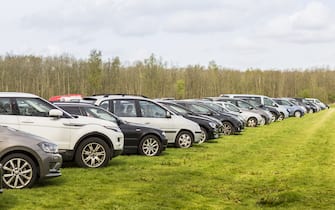 Cars parked outside the Keukenhof on a large field of grass, due to the Keukenhof's popularity space runs out quickly on any given day.