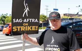 US actor Sean Astin holds a sign while joining members of the Writers Guild of America and the Screen Actors Guild on a picket line outside of Paramount Studios
in Los Angeles, California, on July 14, 2023.. Tens of thousands of Hollywood actors went on strike at midnight July 13, 2023, effectively bringing the giant movie and television business to a halt as they join writers in the first industry-wide walkout for 63 years. (Photo by Michael Tran / AFP) (Photo by MICHAEL TRAN/AFP via Getty Images)