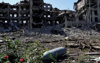 TOPSHOT - A non exploded aviation bomb FAB-250 is pictured in front of a destroyed building in the city of Mariupol on June 2, 2022, amid the ongoing Russian military action in Ukraine. (Photo by STRINGER / AFP) (Photo by STRINGER/AFP via Getty Images)
