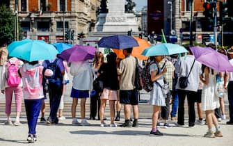 Gente con gli ombrelli per proteggersi dal caldo