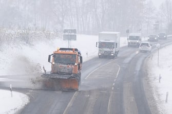 28 November 2023, Saxony, Kamenz: A snow clearing vehicle drives on a snow-covered road. Snowfall, sleet and icy conditions dominate the weather in Saxony. Photo: Sebastian Kahnert/dpa (Photo by Sebastian Kahnert/picture alliance via Getty Images)