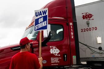 A picketer holds a "UAW On Strike" sign while attempting to block a truck from entering the Ford Motor Co. Michigan Assembly plant in Wayne, Michigan, US, on Tuesday, Sept. 26, 2023. PresidentÂ Joe BidenÂ endorsed theÂ United Auto Workers' demand for a major wage increase during a visit to a picket line at aÂ General Motors Co.Â plant in suburban Detroit, a historic show of solidarity with organized labor. Photographer: Emily Elconin/Bloomberg via Getty Images