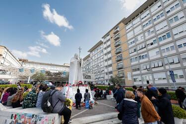 People under the statue of late Pope John Paul II outside Agostino Gemelli Hospital. Pope Francis will be discharged today with prescription for two months of rest after spending more than five weeks in the hospital or a bilateral pneumonia, Italy, 23 March 2025. ANSA/GIUSEPPE LAMI