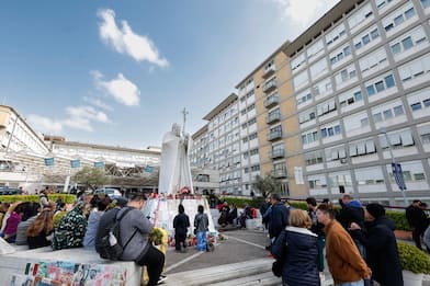 People under the statue of late Pope John Paul II outside Agostino Gemelli Hospital. Pope Francis will be discharged today with prescription for two months of rest after spending more than five weeks in the hospital or a bilateral pneumonia, Italy, 23 March 2025. ANSA/GIUSEPPE LAMI