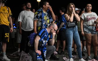 Inter fans react after PSG scored their fourth goal, as they watch outside the San Siro stadium the UEFA Champions League final football match between Paris Saint-Germain (PSG) and Inter Milan held in Munich, in Milan on May 31, 2025. (Photo by PIERO CRUCIATTI / AFP) (Photo by PIERO CRUCIATTI/AFP via Getty Images)          