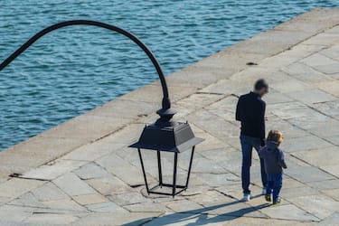 Genitori passeggiano con i figli per le vie del centro, Torino, 2 aprile 2020. ANSA/TINO ROMANO