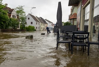 02 June 2024, Bavaria, Wertingen: A man pulls a garbage can across a flooded street. After the heavy rainfall of the last few days, there was severe flooding in the region. Photo: Stefan Puchner/dpa (Photo by Stefan Puchner/picture alliance via Getty Images)