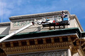 Lavori di pulizia dei graffiti sul frontone della Galleria Vittorio Emanuele II a Milano, 9 agosto 2023. ANSA/MOURAD BALTI TOUATI