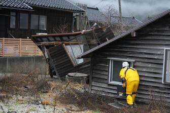 epa11054323 A rescue worker searches for missing people at a collapsed building in Monzen Town, Wajima City, Ishikawa Prefecture, Japan, 03 January 2024. At least 62 people were killed by the magnitude 7 earthquake (the USGS listed the magnitude as 7.5) which occurred on 01 January, according to the Ishikawa Prefecture Government.  EPA/FRANCK ROBICHON