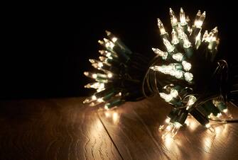 Traditional Christmas Tree lights lying on a wooden floor.