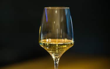 A glass of white wine seen on a table in Mainz, Germany, 03 April 2017. The WineBank offers to securly store wine under ideal conditions. Wine enthusiasts can rent deposit boxes in varying sizes in the subterranean historical Kopferberg vaults. Photo: Andreas Arnold/dpa