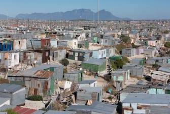 A general view of informal settlements and other parts of Khayelitsha, home to millions of people in mostly impoverished circumstances, with the back of Table Mountain visible, about 35km from the centre of Cape Town on February 22, 2022. - It's been four years since South Africa's tourist capital nearly ran dry, during a drought that left the city limping towards a "Day Zero" when all the pipes would empty.
Now water flows liberally, but not for everyone.
The City of Cape Town estimates that about 31 neighbourhoods have no access to clean water.
That includes sprawling districts filled with shacks, but also working-class neighbourhoods. (Photo by RODGER BOSCH / AFP) (Photo by RODGER BOSCH/AFP via Getty Images)