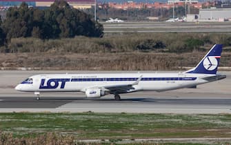 LOT Polish Airlines Embraer ERJ-195LR taxiing along the runway at El Prat Airport in Barcelona, Spain.