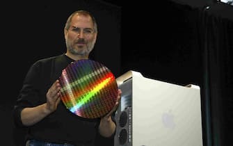 Apple Computer's CEO and co-founder, Steve Jobs holds up an IBM wafer that is used to make the new Power Mac G5 desktop computer (R) during his keynote at the opening of the World Wide Developers Conference in San Francisco. California 23 June 2003. Jobs claims that the high-end dual processor G5 is the world's fastest personal computer.  EPA PHOTO/John G. MABANGLO  EPA PHOTO/EPA/JOHN G. MABANGLO
