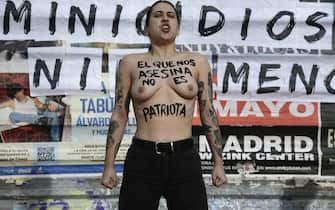 epa11107849 A member of the feminist activist group 'Femen' shows the motto 'who murders us is not a patriot' on her nude torso as she protests to denounce violence against women, in downtown Madrid, Spain, 27 January 2024.  EPA/VICTOR LERENA
