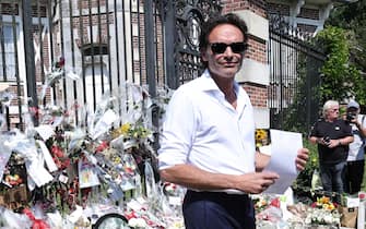 epa11562602 Anthony Delon inspects offerings placed by fans paying tribute to his father, recently deceased French actor Alain Delon, on the gates of the family property in Douchy, France, 24 August 2024. French film legend Alain Delon passed away aged 88 in Duchy, France, his family said in a statement on 18 August.  EPA/Christophe PETIT TESSON