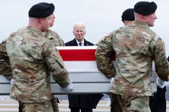 DOVER, DELAWARE - FEBRUARY 02: U.S. President Joe Biden places his hand over his heart while watching a U.S. Army carry team move a flagged draped transfer case containing the remains of Army Sgt. William Rivers during a dignified transfer at Dover Air Force Base on February 02, 2024 in Dover, Delaware. U.S. Army Sgt. William Rivers, Sgt. Breonna Moffett, and Sgt. Kennedy Sanders was killed in addition to 40 other troops who were injured during a drone strike in Jordan. (Photo by Kevin Dietsch/Getty Images)