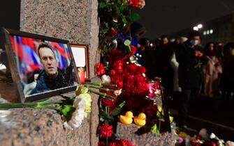 People gather at a makeshift memorial for late Russian opposition leader Alexei Navalny organized at the monument to the victims of political repressions in Saint Petersburg on February 16, 2024, following Navalny's death in his Arctic prison. (Photo by Olga MALTSEVA / AFP)