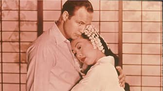 American actor Marlon Brando (1924 - 2004) and Japanese actor Miiko Taka embrace in a scene from the film, 'Sayonara,' directed by Joshua Logan, 1957. (Photo by Fotos International/Getty Images) 