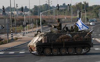 EDITORS NOTE: Graphic content / Israeli forces cross a main road in their armoured personnel carrier (APC) as additional troops are deployed near the southern city of Sderot on October 8, 2023. Israeli Prime Minister Benjamin Netanyahu has warned of a "long and difficult" war, as fighting with Hamas left hundreds dead on both sides after a surprise attack on Israel by the Palestinian militant group on October 7. (Photo by Menahem KAHANA / AFP)
