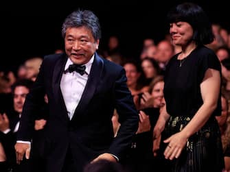 Japanese director Kore-Eda Hirokazu (L) reacts after Japanese writer Sakamoto Yuji won the Best Screenplay prize for the film "Kaibutsu" (Monster) during the closing ceremony of the 76th edition of the Cannes Film Festival in Cannes, southern France, on May 27, 2023. (Photo by Valery HACHE / AFP) (Photo by VALERY HACHE/AFP via Getty Images)