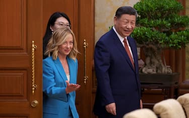 China's President Xi Jinping (R) walks with Italy's Prime Minister Giorgia Meloni (L) for a meeting at the Diaoyutai State Guesthouse in Beijing on July 29, 2024.  (Photo by Vincent Thian / POOL / AFP)