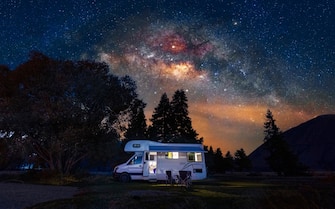 Motorhome at free camp site with milky way sky in New Zealand.