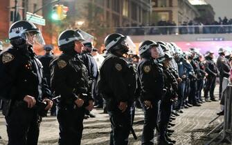 epa11311437 New York City police officers in riot gear look on as officers entered Hamilton Hall at Columbia University after pro-Palestinian protestors barricaded themselves in the building earlier in the day in New York, New York, USA, 30 April 2024. Students have been protesting the university's investments in Israel and showing their support for Palestine for over two weeks, also inspiring other students nationwide to do the same.  EPA/STEPHANI SPINDEL