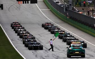 RED BULL RING, AUSTRIA - JULY 10: The green flag is waved as Max Verstappen, Red Bull Racing RB18, and Charles Leclerc, Ferrari F1-75, prepare to lead the field away at the start during the Austrian GP at Red Bull Ring on Sunday July 10, 2022 in Spielberg, Austria. (Photo by Glenn Dunbar / LAT Images)