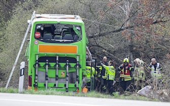 Police officers and emergency personnel react next to a damaged bus on the A9 highway, at the scene of an accident where at least five people were killed, on March 27, 2024 in Schkeuditz, near Leipzig, eastern Germany. (Photo by Jens Schlueter / AFP) (Photo by JENS SCHLUETER/AFP via Getty Images)